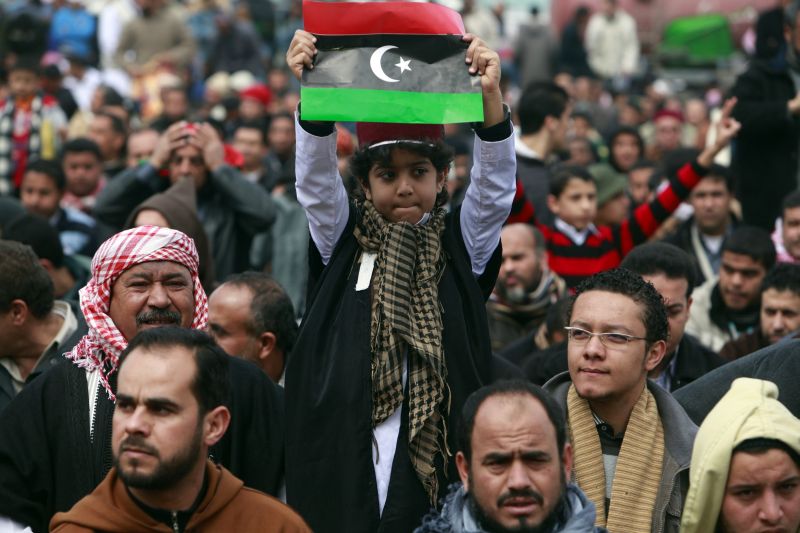 Criança segura bandeira da Líbia em meio à manifestação em Benghazi | Reuters