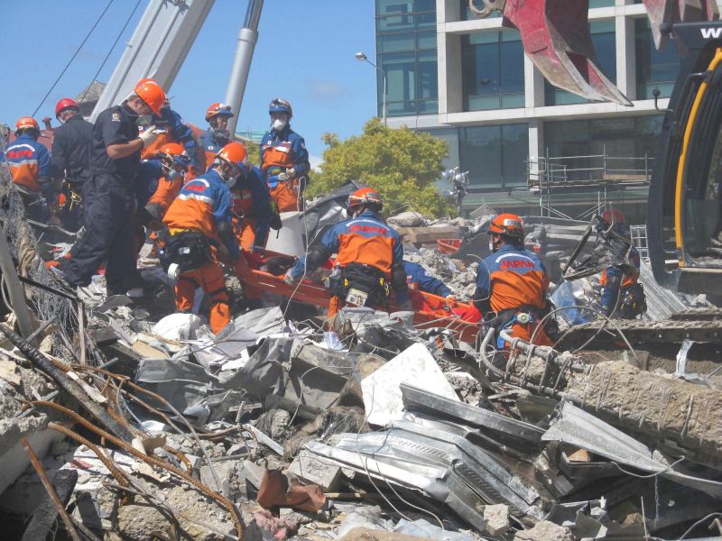 Equipes de resgate japonesas em frente aos escombros do prédio da CTV, em Christchurch. O número de mortos pelo terremoto desta semana na Nova Zelândia chegou a 113, mas equipes de resgate temem que o total supere 200 | Reuters