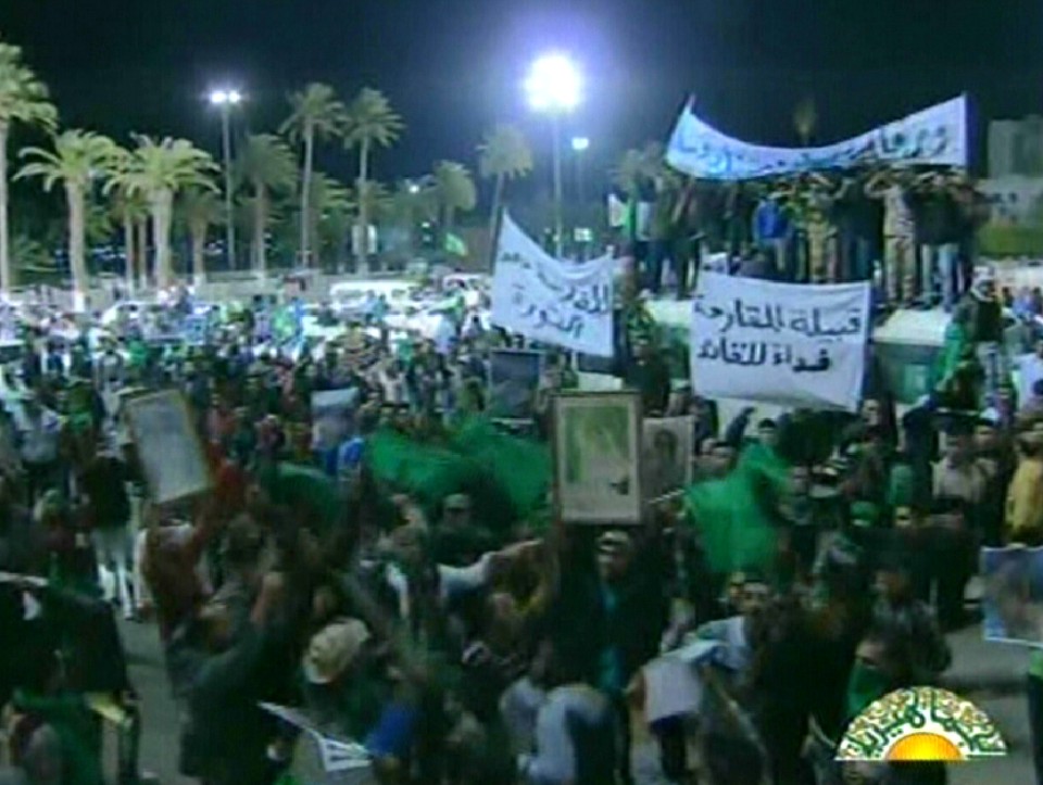 Imagem do canal de TV do governo mostrando manifestantes que apoiam Kadafi reunidos em praça na cidade de Tripoli enquanto reportavam que caças do países estavam atacando opositores do regime | AFP PHOTO/HO/LIBYAN TV