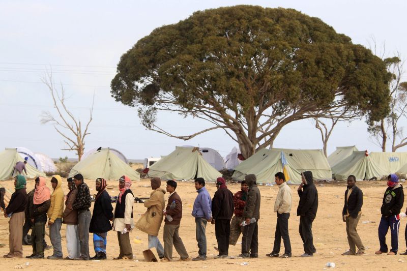 Evacuados da Líbia fazem fila para receber comida, em campo na Tunísia | Pascal Rossignol/Reuters