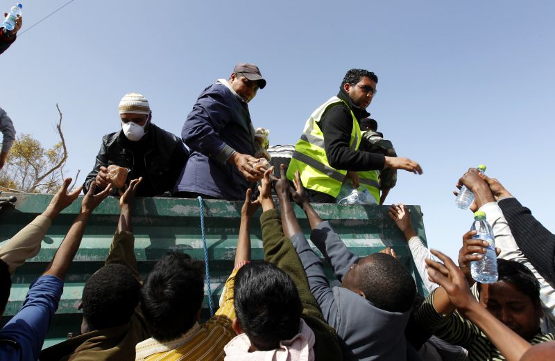 Voluntários tunisianos entregam comida e água aos refugiados. Nações Unidas alertam para crise humanitária | Zohra Bensemra/Reuters