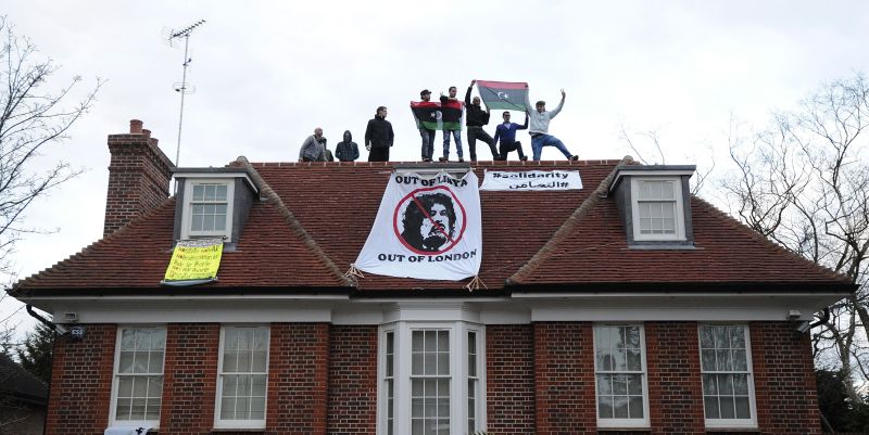 Grupo de invasores residenciais pede a saída de Kadafi após ocupar a casa de familiares do ditador, em Londres | Suzanne Plunkett/Reuters