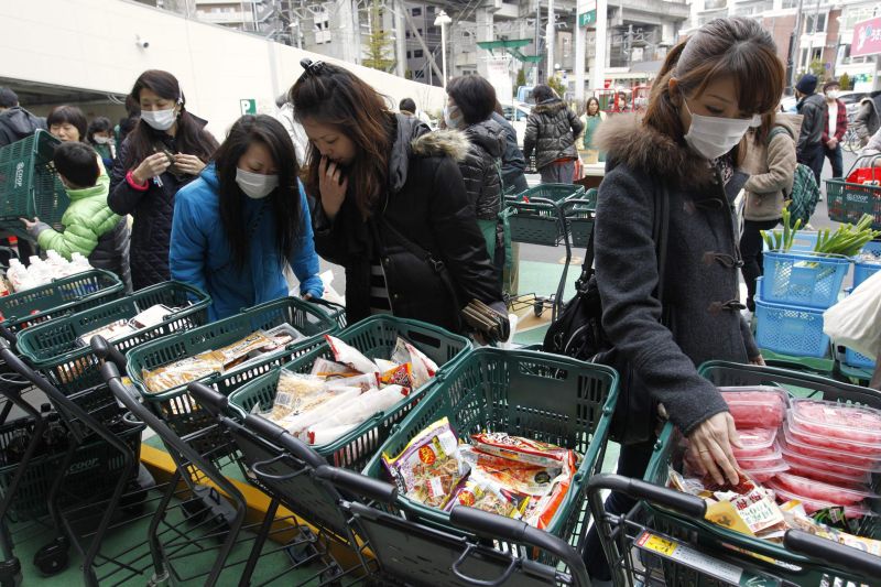 Moradores de Sendai, uma das cidades arrasadas pelo terremoto e tsunami, compram alimentos em mercado improvisado | Kyodo/ Reuters