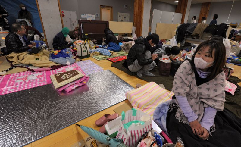 Desabrigados usam máscaras para se proteger de radiação em abrigo improvisado pelo governo, em Sendai | Mike Clarke/AFP