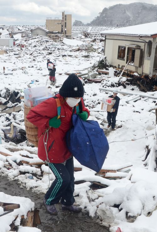 Moradores de Miyako procuram pertences em meio à neve. Depois da devastação, vítimas enfrentam o frio | Noguch Takashi /AFP