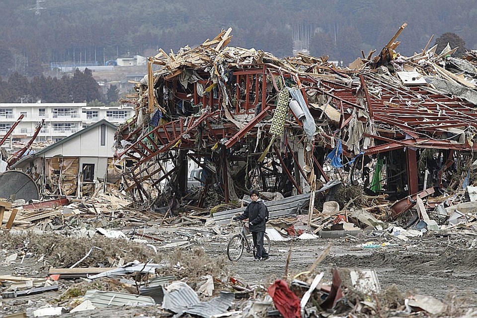 Garoto caminha em um vilarejo destruído pelo tsunami no Japão | REUTERS/Toru Hanai