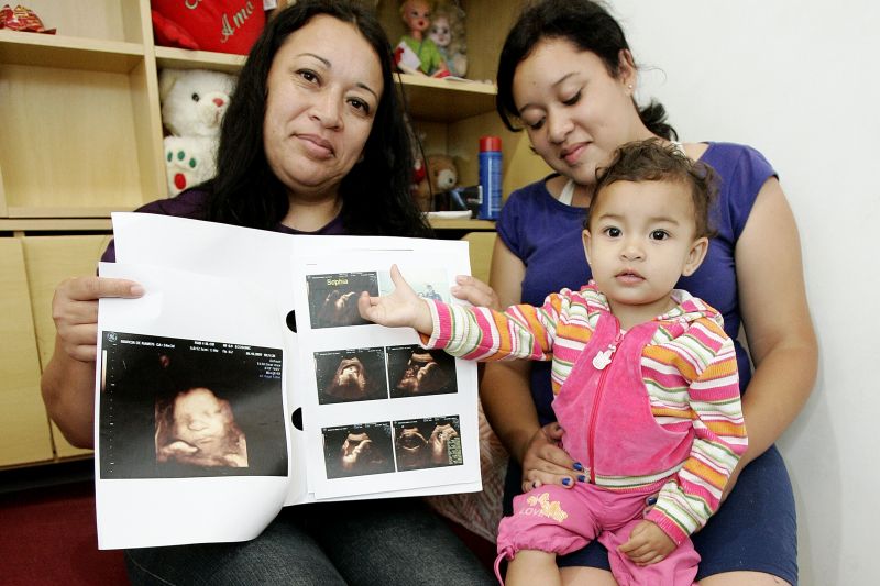 A vigilante Márcia de Ramos Pereira com as filhas Amanda, de 23 anos, e Julia de 1 anos e meio: gravidez de risco por causa da pressão alta | Antônio More / Gazeta do Povo