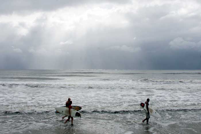 Surfistas e pescadores foram os únicos a enfrentarem o mar agitado e a chuva nesta terça | Walter Alves / Agência de Notícias Gazeta do Povo