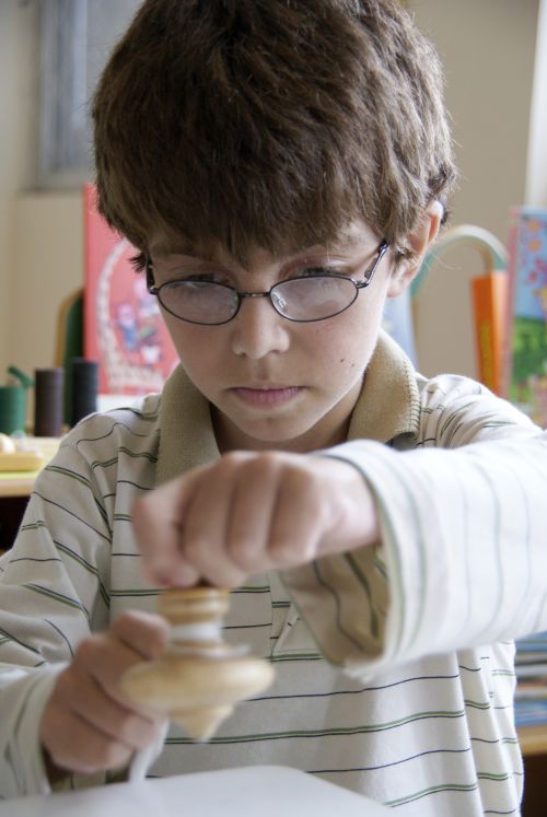 Guilherme, 11 anos, descobre novos tipos de piões e as manobras que pode fazer com eles depois de receber dicas do especialista em brinquedos antigos Cláudio Teixeira | Marco Antonio LIma/Gazeta do Povo