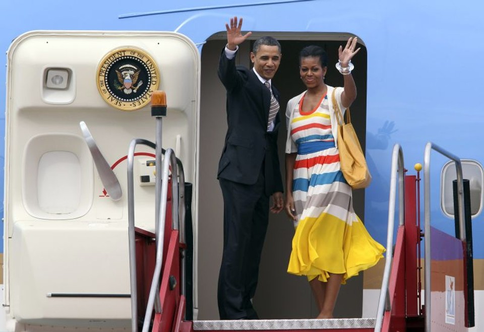 O presidente e primeira-dama dos Estados Unidos acenam ao entrar no avião que seguirá para Santiago | Sergio Moraes/Reuters