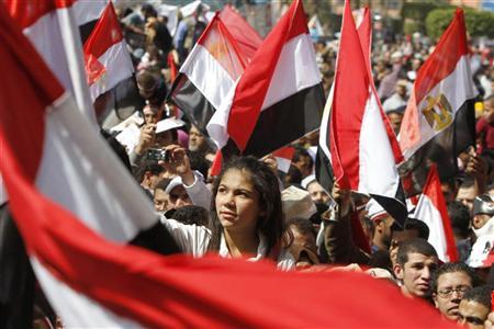 Egípcios levantam bandeira do país em comício pró-democracia na praça Tahrir, Cairo | Reuters