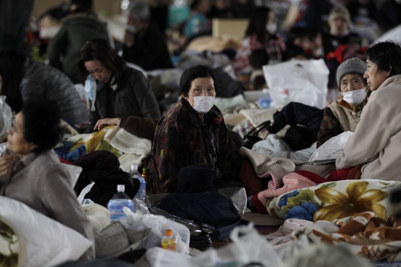 Mulher que deixou os arredores da usina nuclear de Fukushima é vista em um centro de desabrigados em Kawamata, norte do Japão | Reuters