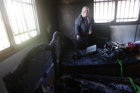 Mulher palestina observa os danos causados por colonos israelenses durante a noite, na Cisjordânia, 1o de março de 2011 | REUTERS/Abed Omar Qusini