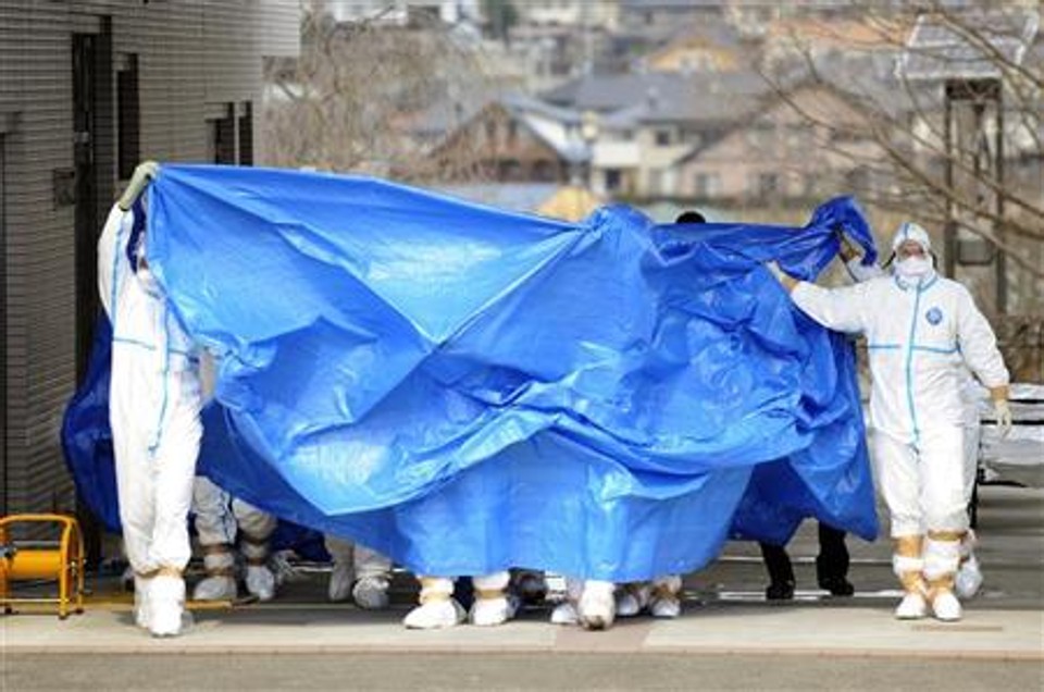 Membros da Força de Defesa do Japão em roupas protetoras se preparam para transferir para outro hospital os trabalhares que foram expostos à  radiação no usina nuclear | Reuters