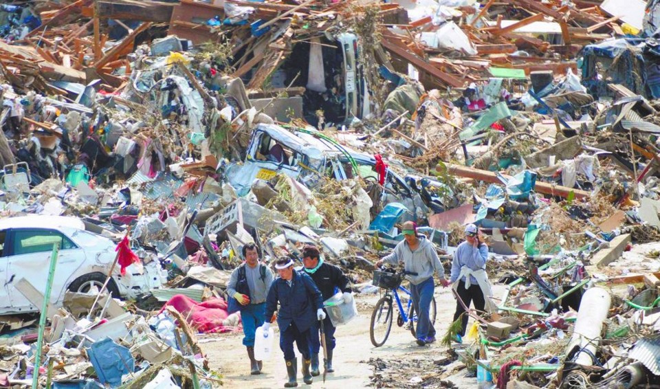 Sobreviventes tentam encontrar pertences em meio a ruínas de Rikuzentakata, uma das cidades destruídas pelo terremoto e pelo tsunami que atingiram o Japão na sexta-feira | Kyodo/Reuters