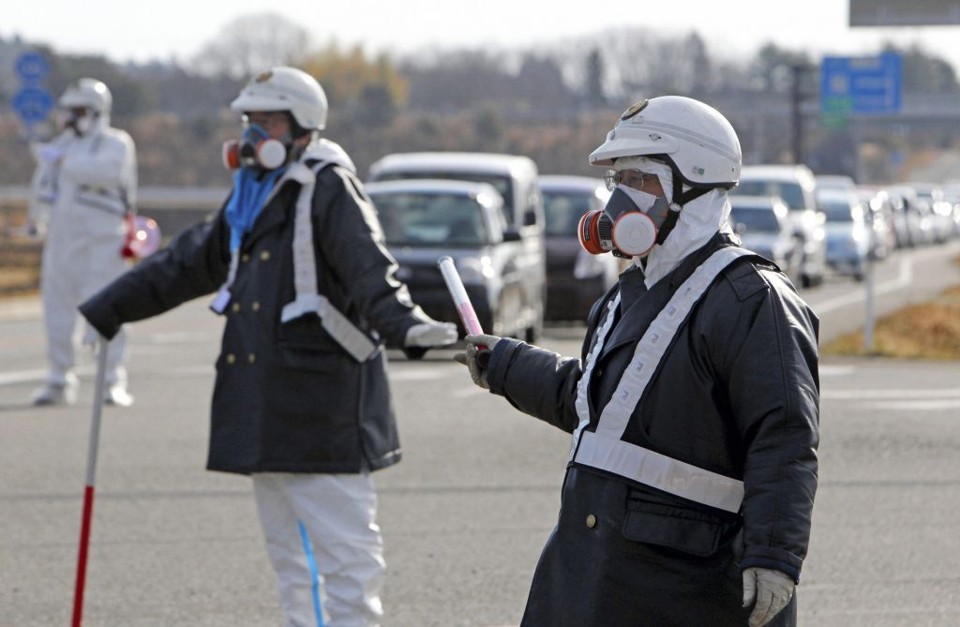 Oficiais orientam habitantes que se retiram da região da cidade de Fukushima, onde fica instalada a usina nuclear de Daiichi | Asahi Shimbun/Reuters