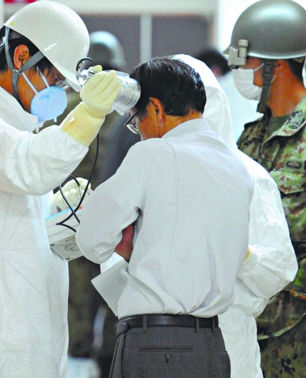 Técnico usa detector de radioatividade em morador de área evacuada: riscos à saúde pública ainda são considerados baixos | Kyodo/Reuters