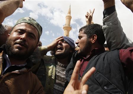Rebeldes líbios lamentam pelos mortos em um conflito com forças pró-Kadafi em Brega, na Líbia | REUTERS/Asmaa Waguih