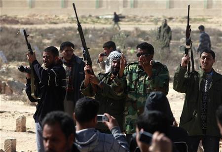 Manifestantes da oposição atiram durante funeral de rebedes que morreram na quarta-feira, durante conflitos com forças de Kadafi | Reuters