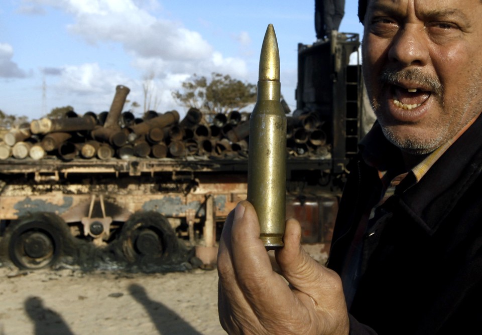 Homem segura munição na estrada entre Benghazi e Ajdabiyah, no leste da Líbia, nesta segunda-feira | Reuters