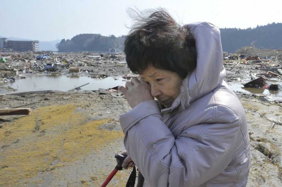 Mulher chora no lugar onde, até sexta-feira, ficava a cidade de Minamisanriku, a localidade mais próxima do epicentro do terremoto | Kyodo/Reuters