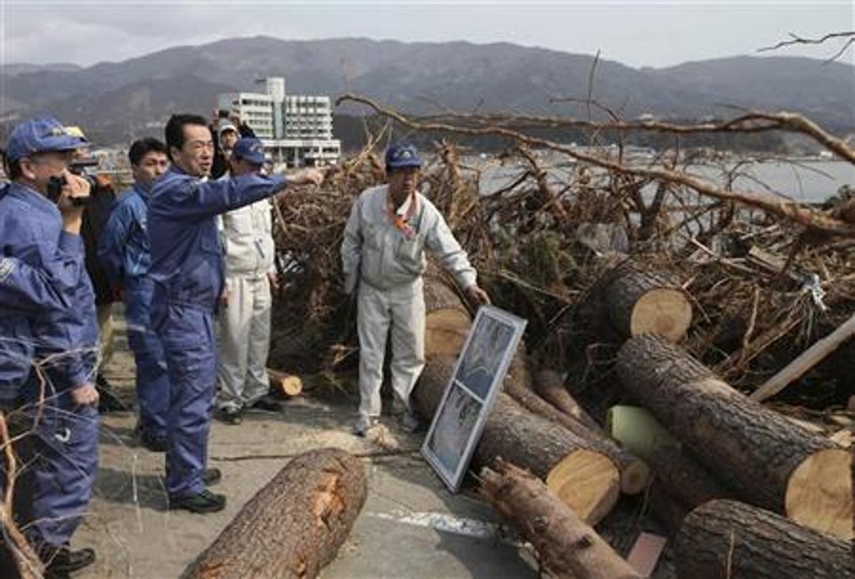 Premiê japonês, Naoto Kan, aponta para local danificado em sua visita à cidade de Rikuzentakata, que foi afetada pelo terremoto acompanhado de tsunami. 02/04/2011 | Reuters