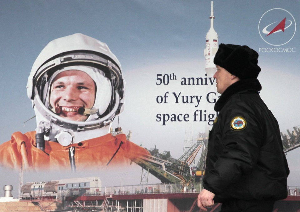 Um homem passa pela imagem do cosmonauta russo Yuri Gagarin | REUTERS/Alexander Natruskin