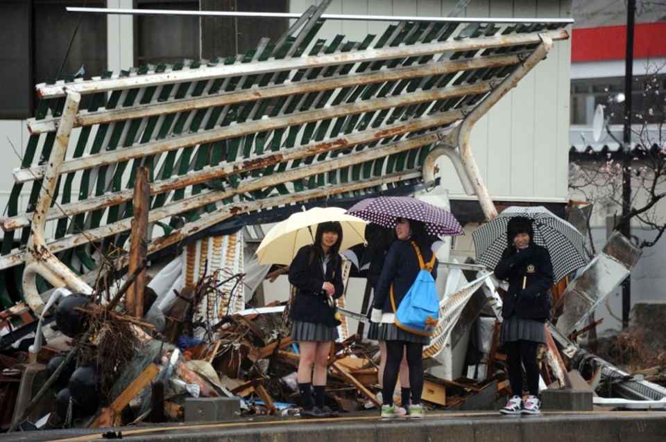 Estudantes caminham em meio aos estragos feitos pelo tsunami em Miyako, na província de Iwate | Toshifumi Kitamura/AFP