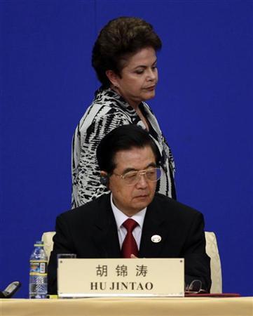 A presidente Dilma Rousseff passa atrás do presidente da China, Hu Jintao, depois de discursar em uma conferência na cidade chinesa de Boao | REUTERS/Jason Lee