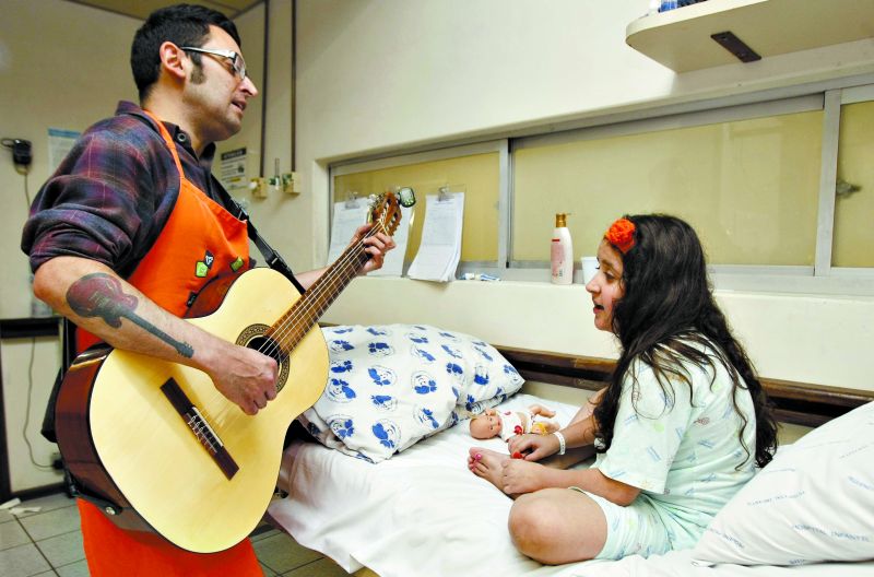 No Hospital Pequeno Príncipe, a música é usada para aliviar as dores dos pacientes e para animar as crianças internadas que ficam angustiadas. Na sequência, os pacientes Rafaela, Pablo e Paulo com o músico Ricardo Pacheco | Fotos: Jonathan Campos/ Gazeta do Povo