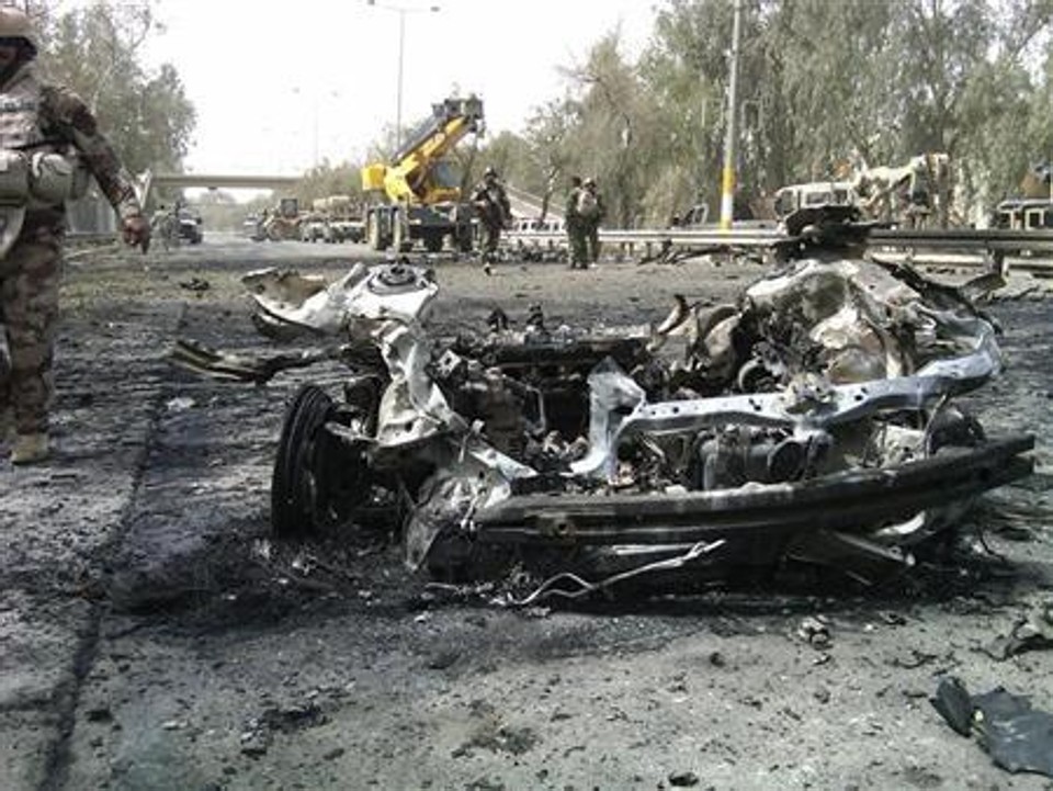 Destroços de um carro-bomba na Zona Verde de Bagdá. Dois carros-bomba explodiram perto de um posto de checagem de segurança numa movimentada entrada da Zona Verde, área altamente fortificada de Bagdá, matando cinco pessoas e ferindo outras 15 | REUTERS/Haider Kadhim