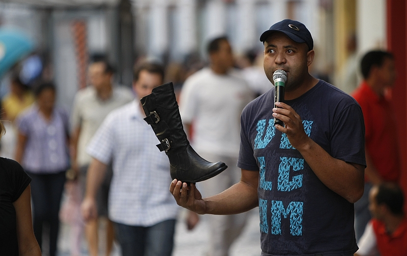 Daniel de Oliveira Costa, locutor no Centro de Curitiba: energia é bom humor para atrair o público para a loja de calçados | Jonathan Campos/ Gazeta do Povo