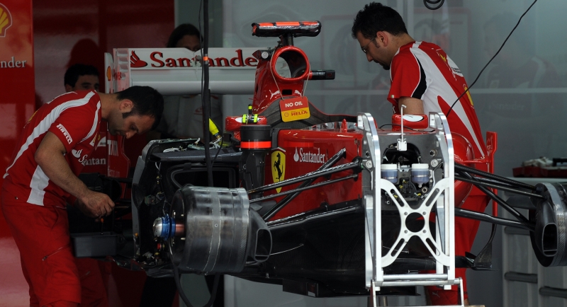 Mecânicos ajustam o carro da Ferrari para o GP da Malásia, neste fim de semana, atendendo a uma solicitação de Fernando Alonso, principal piloto da escuderia | Saeed Khan/ AFP