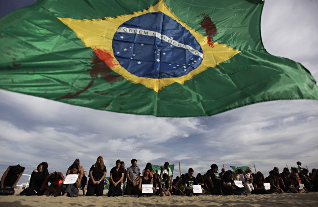 Bandeiras manchadas foram colocadas ontem na praia de Copacabana, no Rio, para homenagear os adolescentes mortos na semana passada | Ricardo Moraes/Reuters