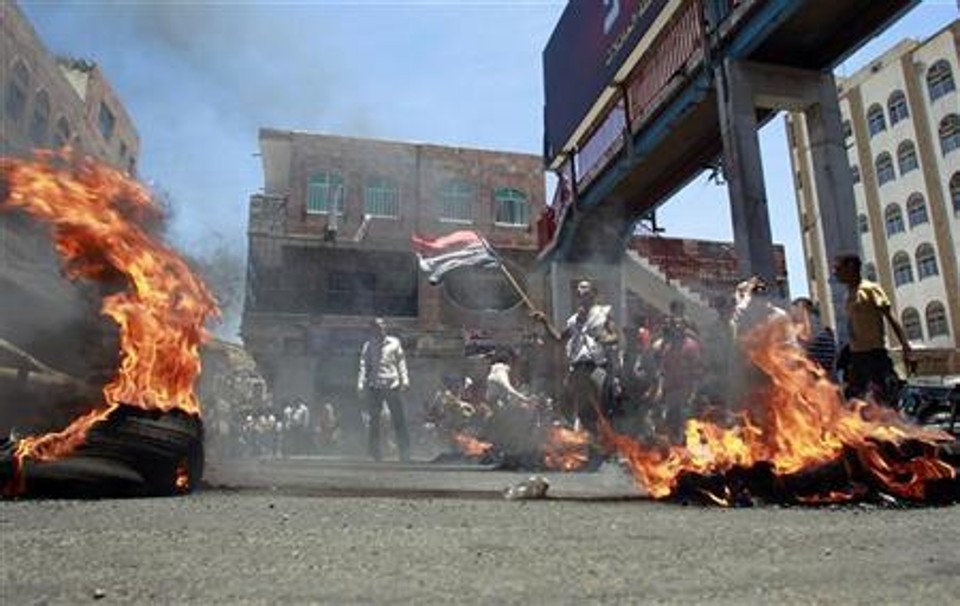 Manifestantes queimam pneus durante protestos exigindo a renúncia do presidente Ali Abdullah Saleh | REUTERS/Khaled Abdullah