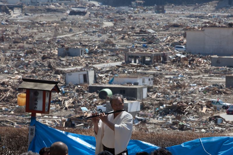 Japonês toca flauta em celebração de primavera na região destruída de Rikuzentakata: crise ainda presente | Yasuyoshi Chiba/AFP