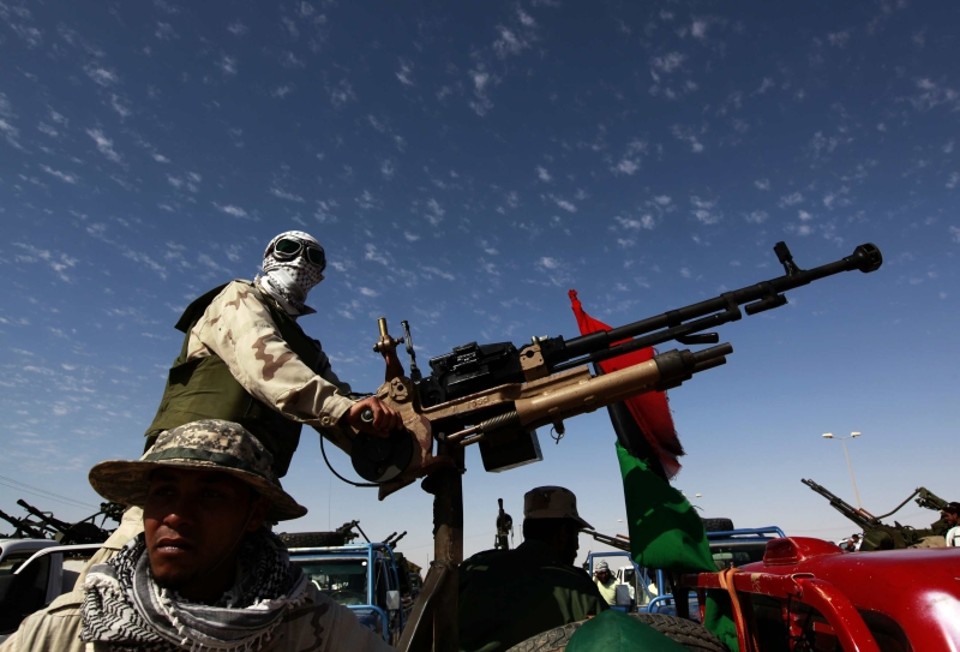Guerrilheiro portando metralhadora antiaérea varre o céu em busca de aviões da Otan, em Ajdabiyah | Reuters