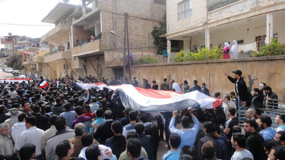 Manifestantes seguram uma bandeira da Síria, durante uma manifestação Zabadani, perto de Damasco 22 de abril de 2011 | Reuters