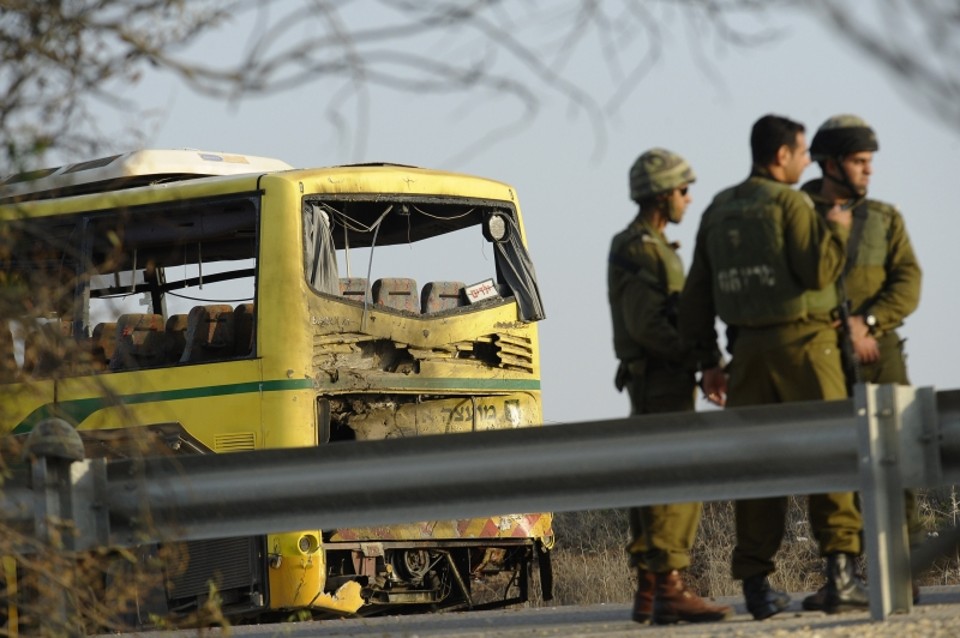 Soldados israelenses próximos ao ônibus atingido por mísseis. O ataque resultou na morte de 5 pessoas | AFP
