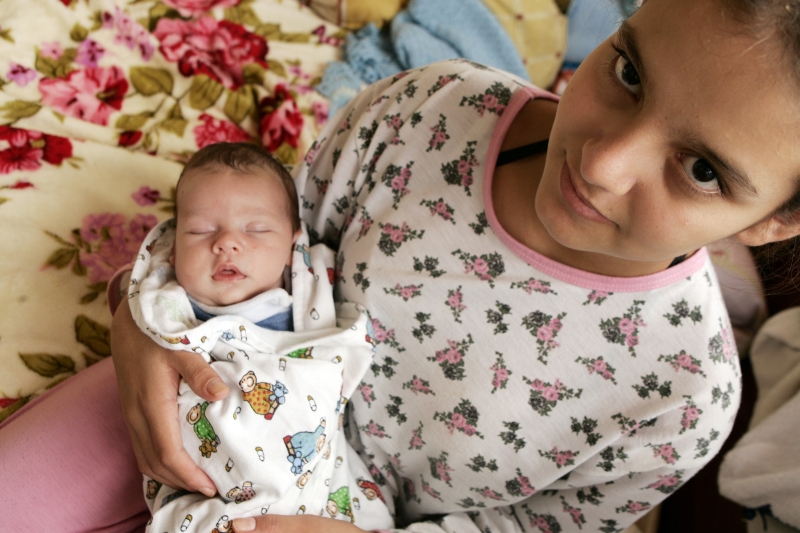 Com o filho Cauã no colo e longe da escola, Janaina, de 16 anos, ainda está se adaptando à rotina de mãe adolescente | Henry Miléo/Gazeta do Povo