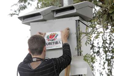 Durante a manhã de ontem, funcionários da Urbs começaram a adesivar os 119 radares de Curitiba, colocando o brasão municipal sobre a marca da Consilux | Luiz Costa/SMCS