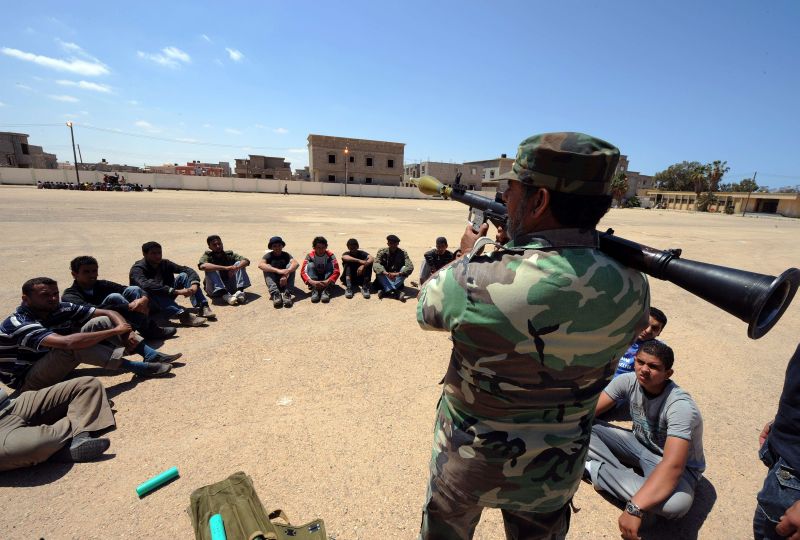 Jovens rebeldes líbios aprendem a utilizar o lançador de granadas durante a fase final do treinamento, em Benghazi | AFP