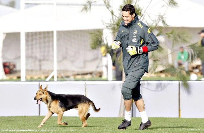 Roubando a cena -As atenções estavam voltadas para Neymar ontem, no primeiro treino do jogador pela seleção brasileira após a conquista da Libertadores com o Santos dois dias antes. Até um cachorro roubar a cena. O dócil vira-lata  com traços de pastor alemão , que já circula há alguns dias pelo local, fez o aquecimento correndo ao lado dos três goleiros da seleção (na foto com o titular Júlio César) de um lado para o outro da área. Depois saiu em disparada para o outro lado do campo, onde os demais jogadores se alongavam, dando um olé no segurança que o perseguia. No fim, virou até personagem de matéria da Rede Globo | 
