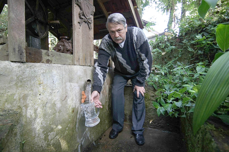 O empresário Nelito Simão mostra com orgulho a água da nascente que brota em seu restaurante. Segundo ele, análises mostraram que a água é boa | Fotos: Aniele Nascimento/ Gazeta do Povo