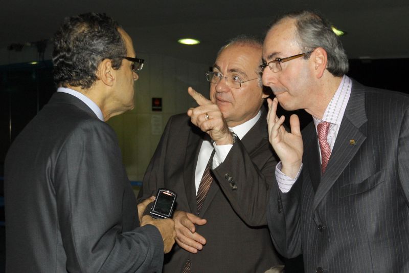 O líder do PMDB na Câmara, Henrique Eduardo Alves (de costas), conversa com o líder do partido no Senado, Renan Calheiros, observado pelo deputado Eduardo Cunha (PMDB-RJ): concordância sobre cargos, mas não de nomes | Dida Sampaio/AE