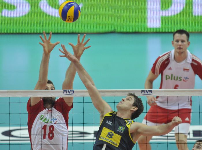 O levantador Bruninho disputa a bola na rede com o polonês Marcin Mozdzonek, na partida disputada em Katowice | FIVB/ Divulgação