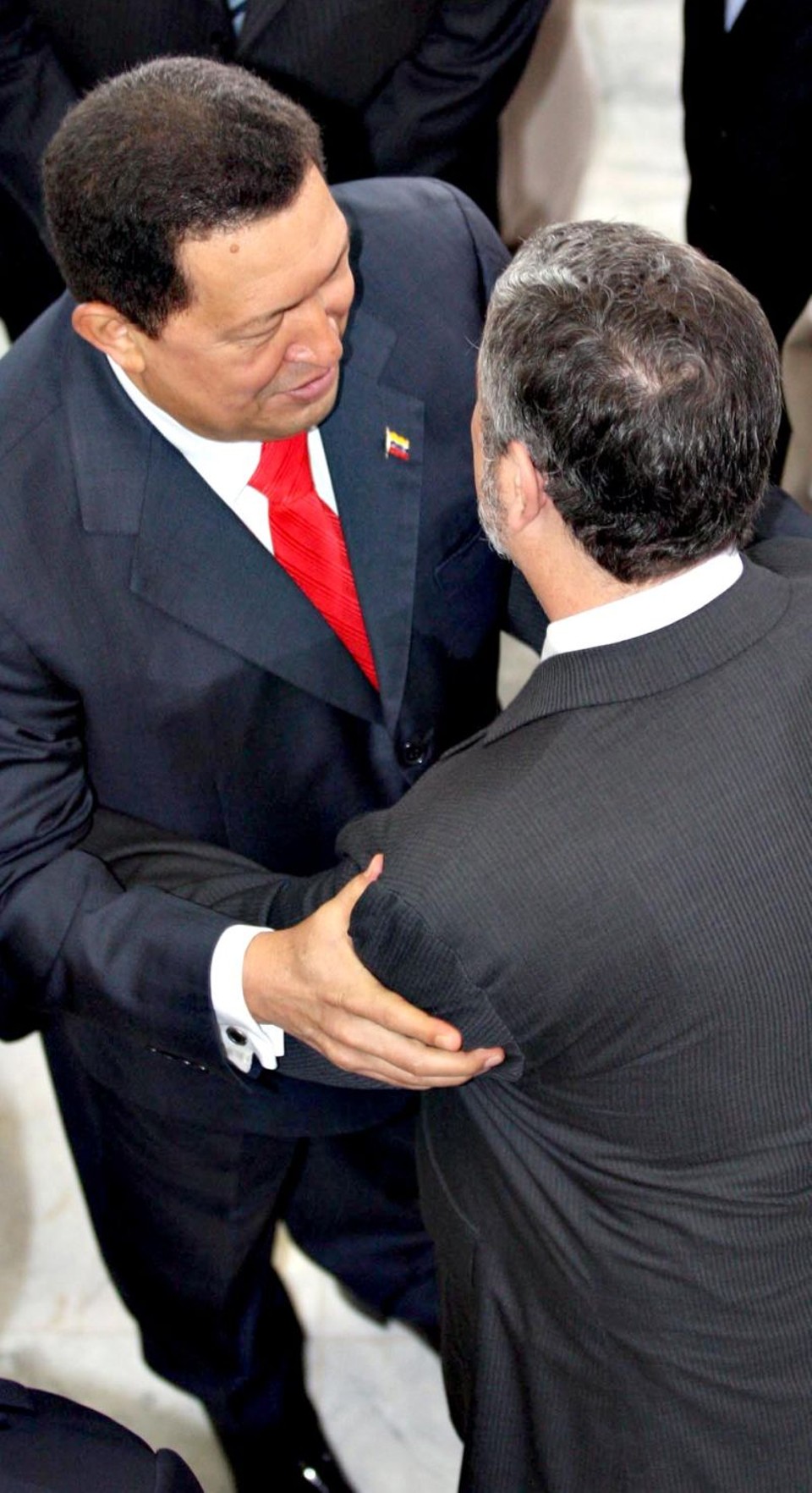 "Fuerza, Palocci", diz Chávez -O presidente da Venezuela, Hugo Chávez, visitou ontem a presidente Dilma Rousseff, em Brasília, e foi recepcionado por diversos ministros, incluindo Antonio Palocci. Chávez deu um abraço em Palocci (de costas na foto) e desejou "força" ao ministro da Casa Civil, alvo de denúncia de suspeita de enriquecimento ilícito. "Fuerza, fuerza", afirmou Chávez, ao cumprimentar Palocci, na chegada ao Palácio do Planalto.  Embora tenha tentado transparecer que estava em uma rotina de normalidade durante a visita do venezuelano, Palocci fugiu da imprensa logo após almoço em homenagem a Chávez, no Palácio do Itamaraty. Ele teve de mobilizar funcionários do Ministério das Relações Exteriores para encontrar uma maneira de sair do prédio sem ser abordado pelos jornalistas  o que envolveu a troca por três vezes da portaria pela qual ele sairia. Já Dilma se recusou a responder perguntas sobre o futuro de Palocci | André Dusek/AE