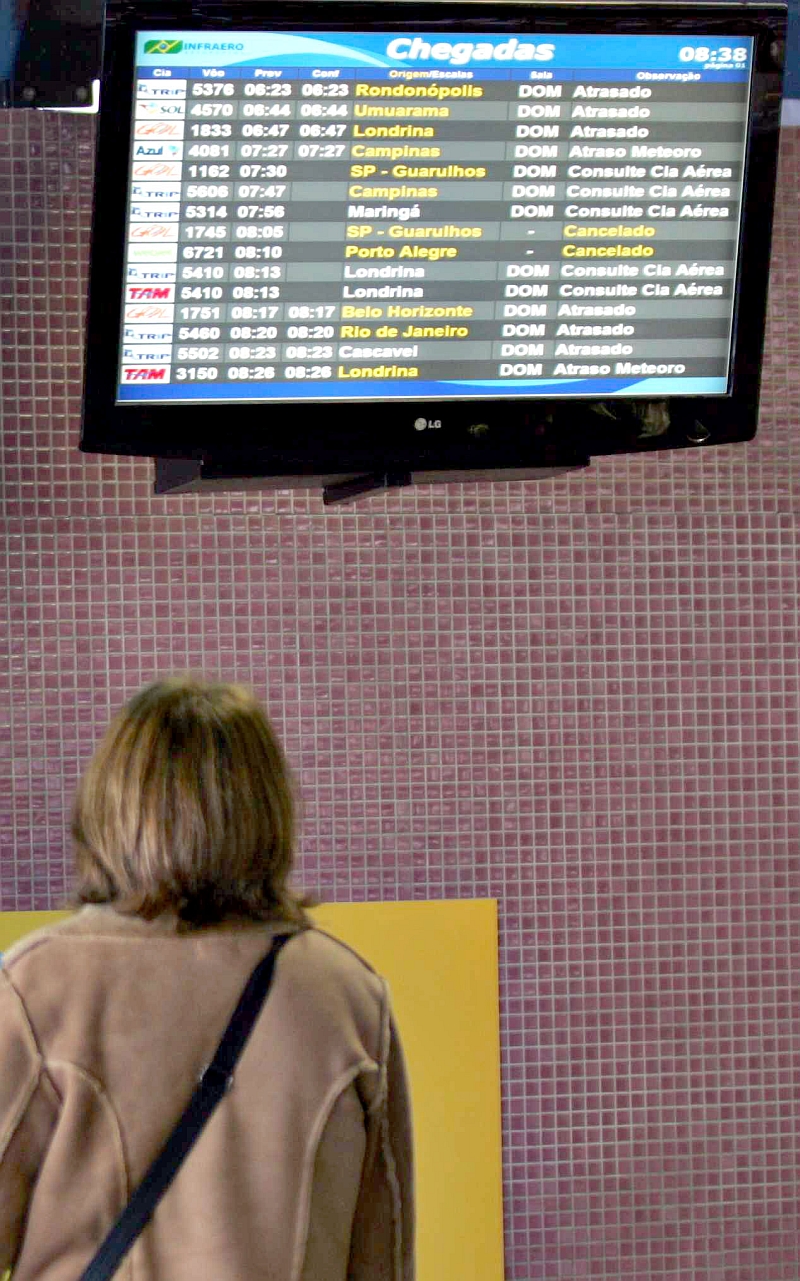 Passageira observa horários no Afonso Pena: manhã de hoje também terá neblina | Aniele Nascimento/Gazeta do Povo