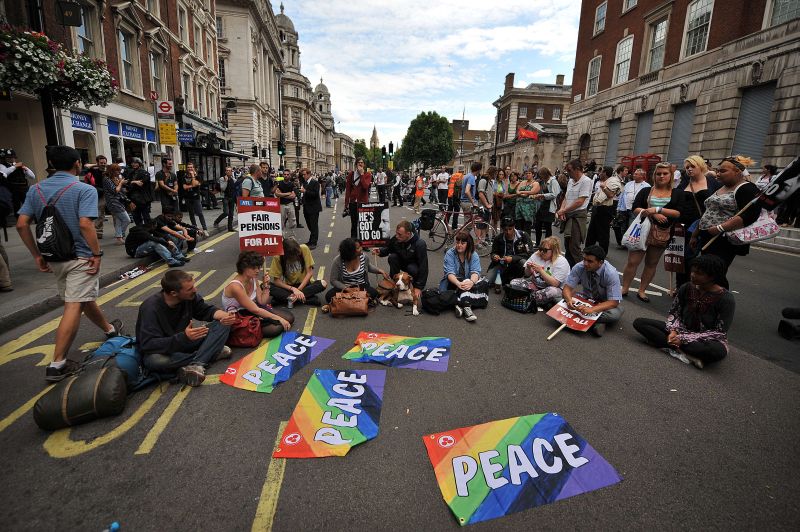 Manifestantes sentaram no chão bloqueando as ruas para prostestar contra as reformas previdenciárias e medidas de austeridade do governo britânico | AFP