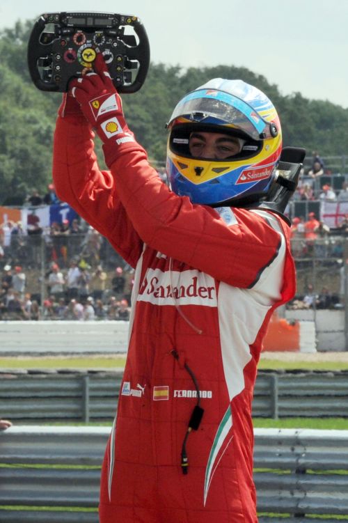 Fernando Alonso aponta para o símbolo da Ferrari no volante do carro: espanhol conseguiu quebrar a supremacia da Red Bull | Tom Gandolfini/AFP